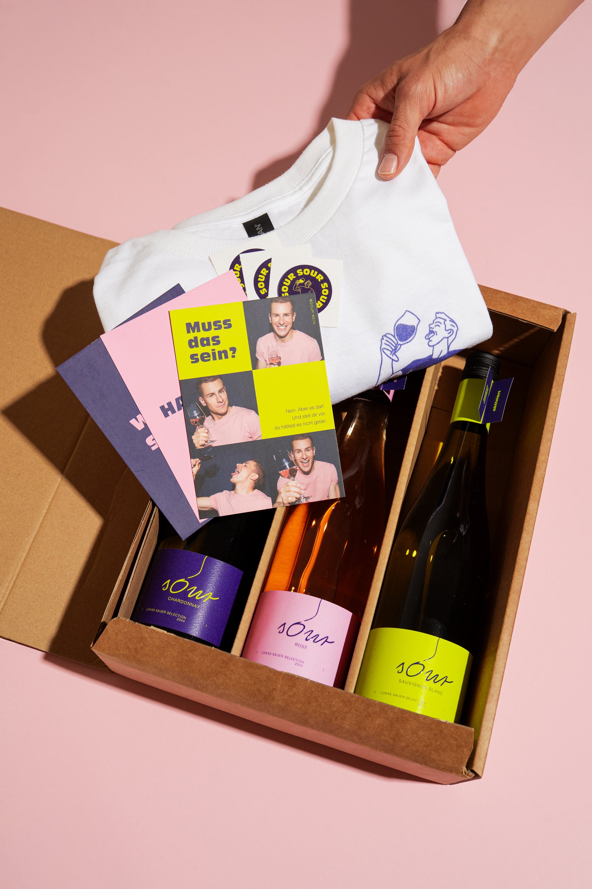 sOur SoURPRISE Kombibox mit Wein, T-Shirt, Stickern und Postkarten – limitierte Geschenkbox von Lukas Sauer